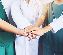 Ein Team legt die Hände übereinander